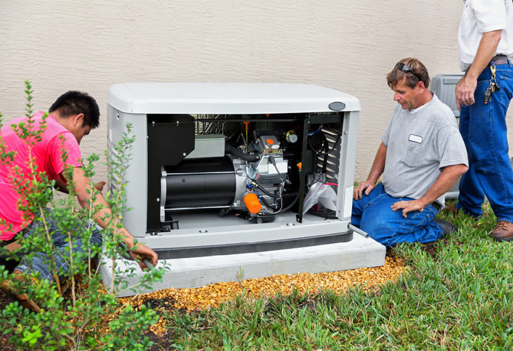 Three men installing a brand new home backup generator