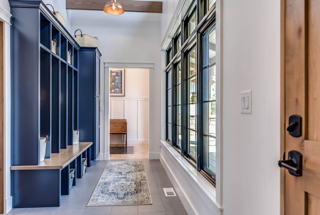 A sophisticated mud room with blue wooden cubbies and bright windows