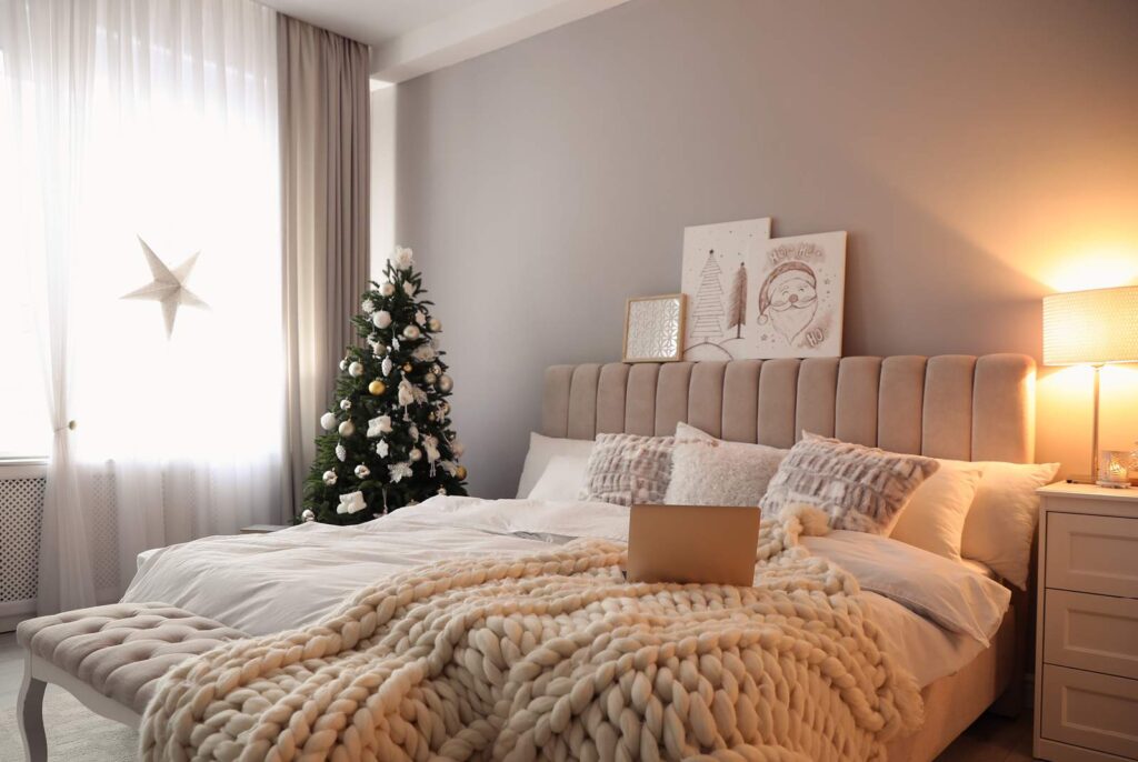 A cozy guest bedroom decorated for the holidays with smooth walls and ceiling