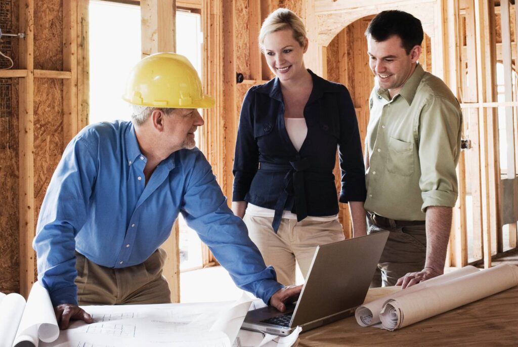 Homeowners reviewing work progress with a Get Dwell Project Manager in a hard hat in a building undergoing remodeling