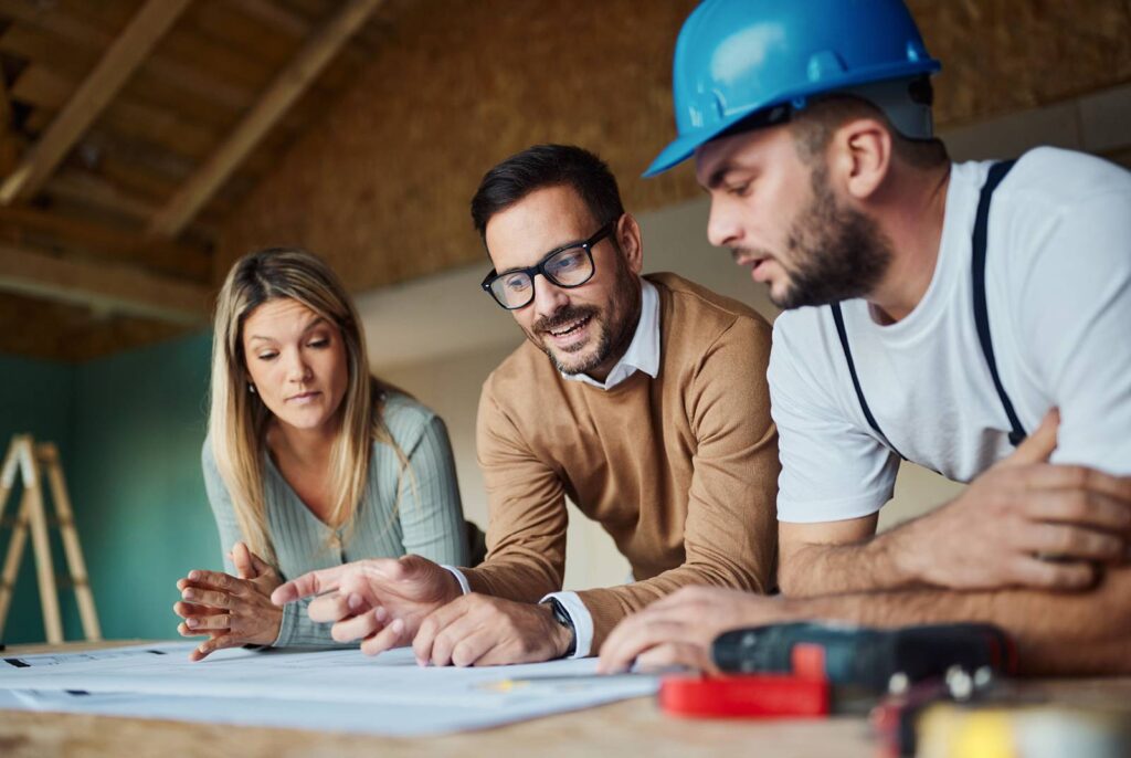 Female homeowner with architect and Get Dwell carpenter reviewing remodeling plans