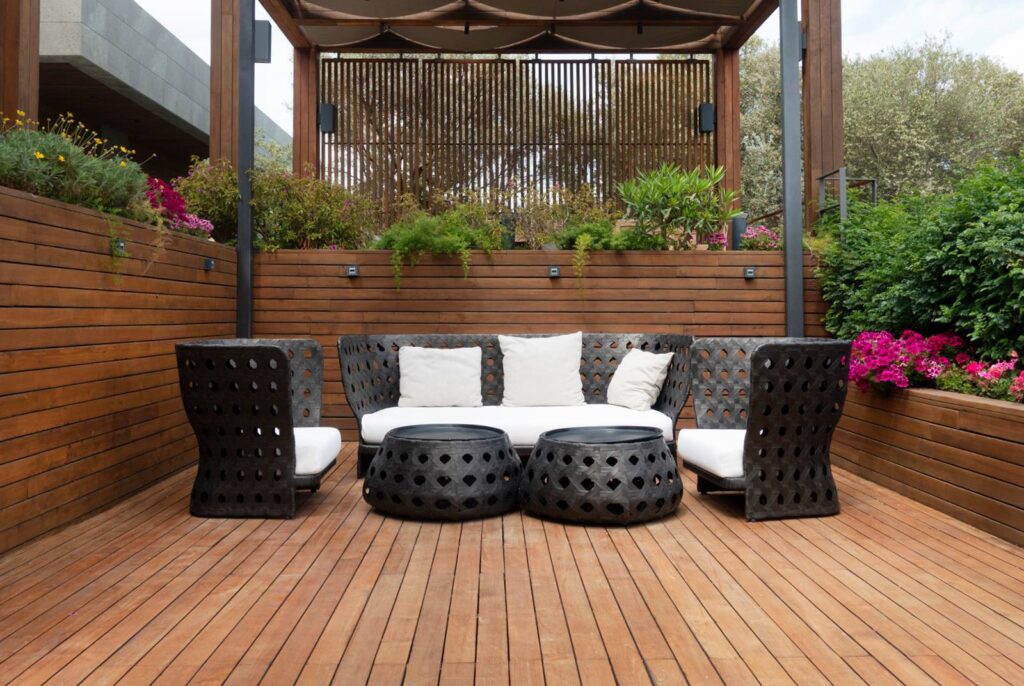 A sleek, modern wooden deck with high end wicker furniture