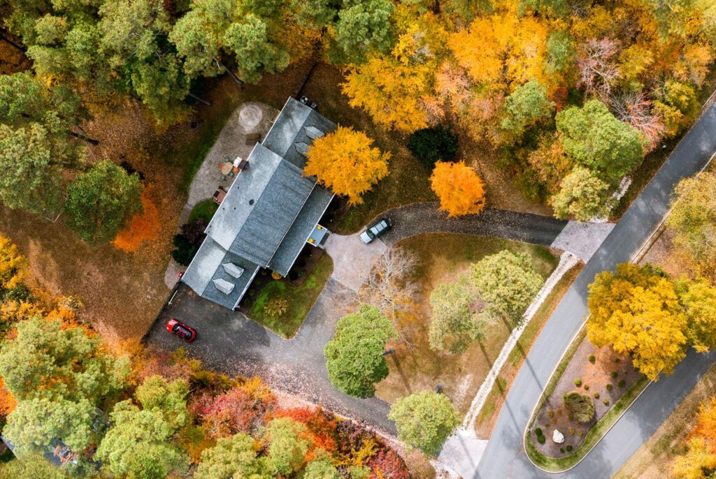 Aerial view of a North Shore Chicago house's roof surrounded by trees with colorful fall foliage.
