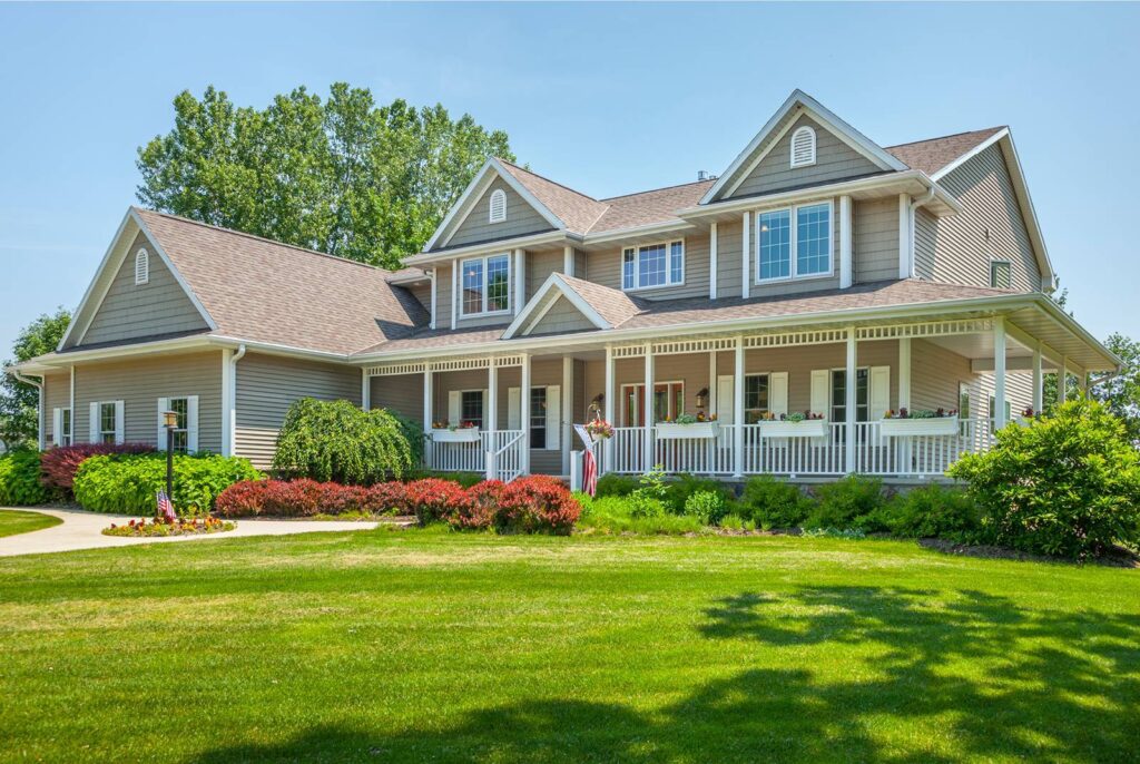 exterior of home with painted shake and frame siding and a wraparound porch