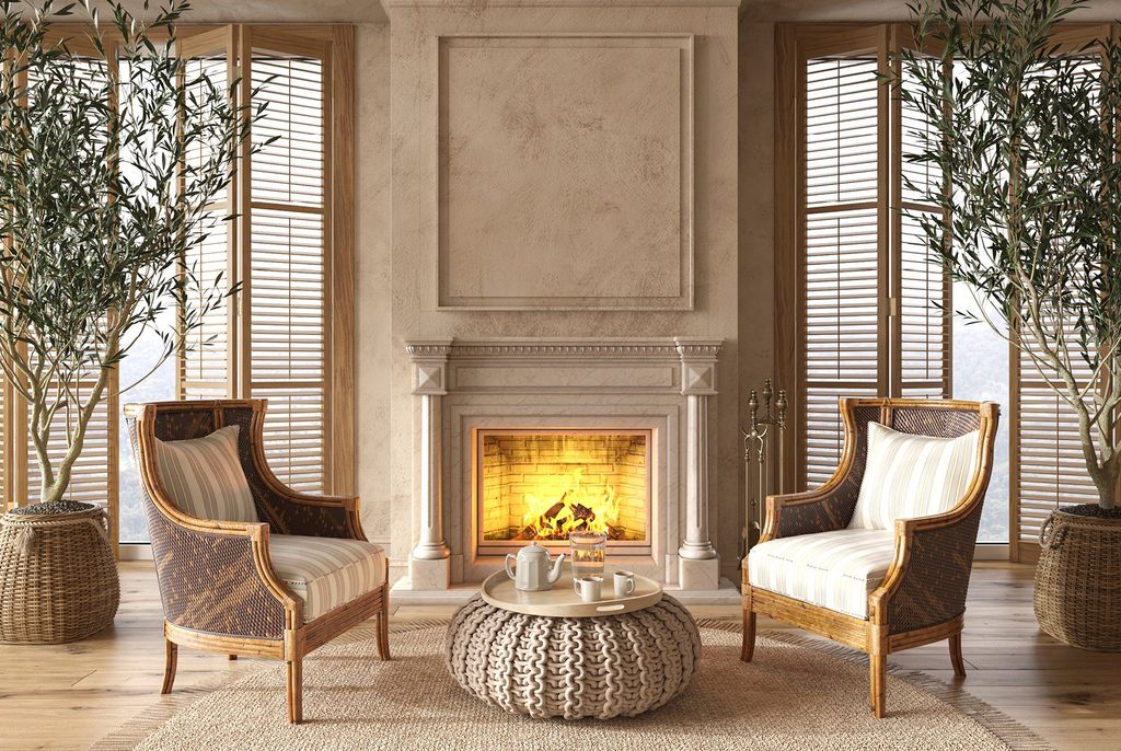 A beautiful fireplace with two chairs and an ottoman